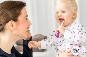 bebe con su mamá cepillandose los dientes