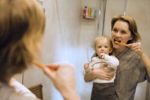 mamá cepillando a su bebé frente al espejo