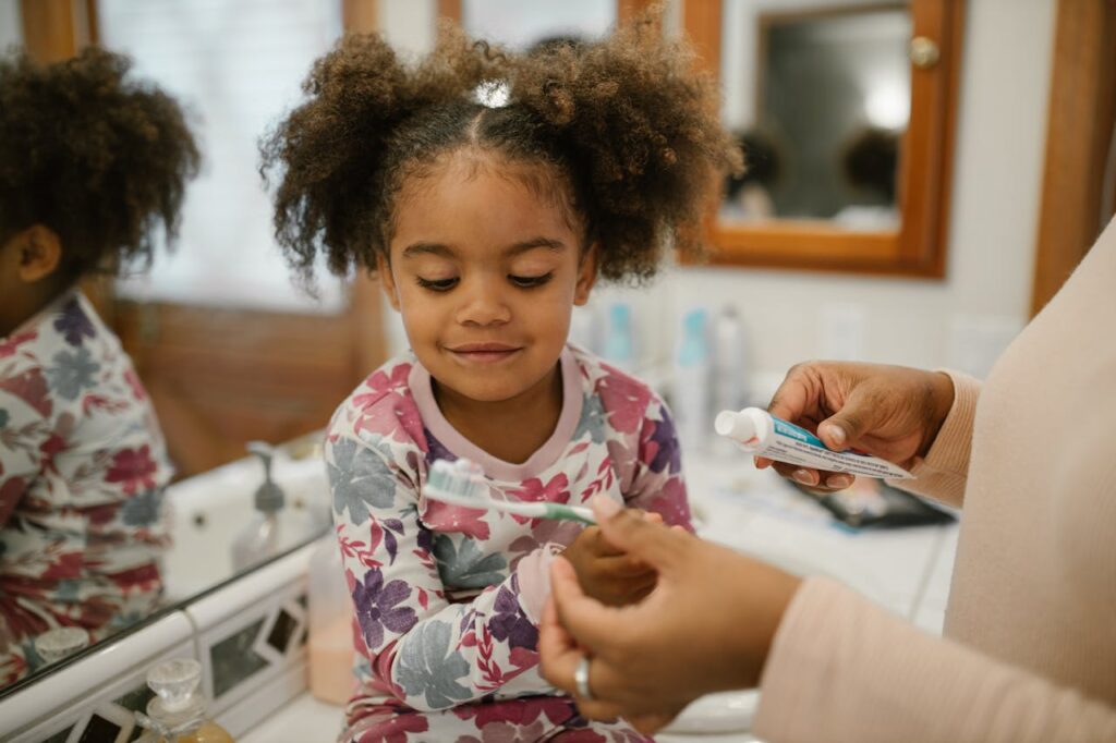 Cepillo eléctrico y manual en niños, una niña se asea los dientes con sus mamá