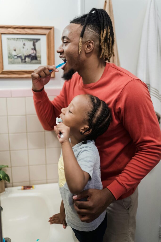 Cepillo eléctrico y manual en niños, papá e hijo se limpian los dientes todos los días después de cada comida